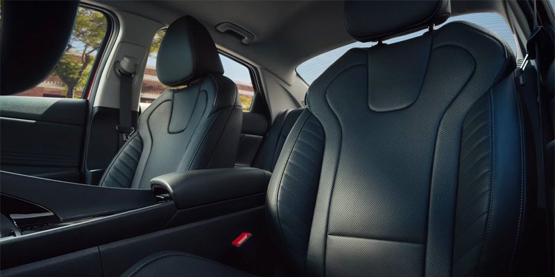 Vista interior de un coche con asientos deportivos de cuero perforado de color gris oscuro.