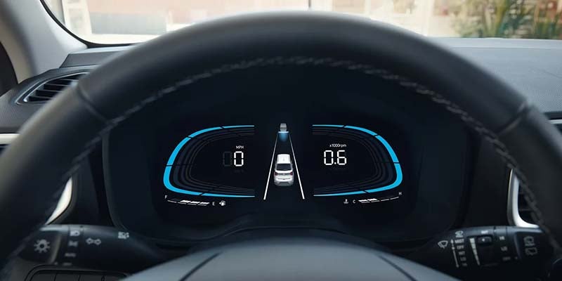 Digital dashboard of a car with a speed of 0 mph, fuel gauge, and lane keeping assist graphic active.
